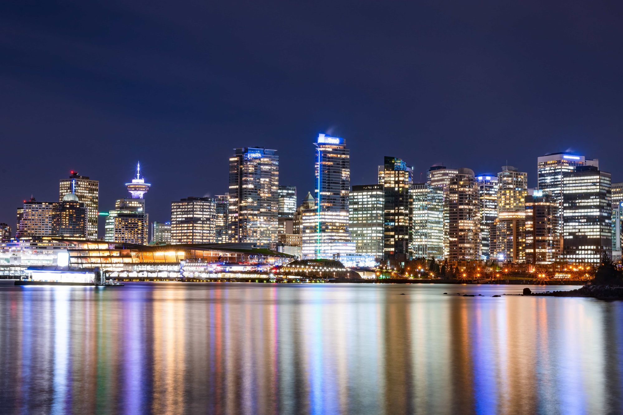 The downtown Vancouver skyline at night, reflected in Coal Harbour